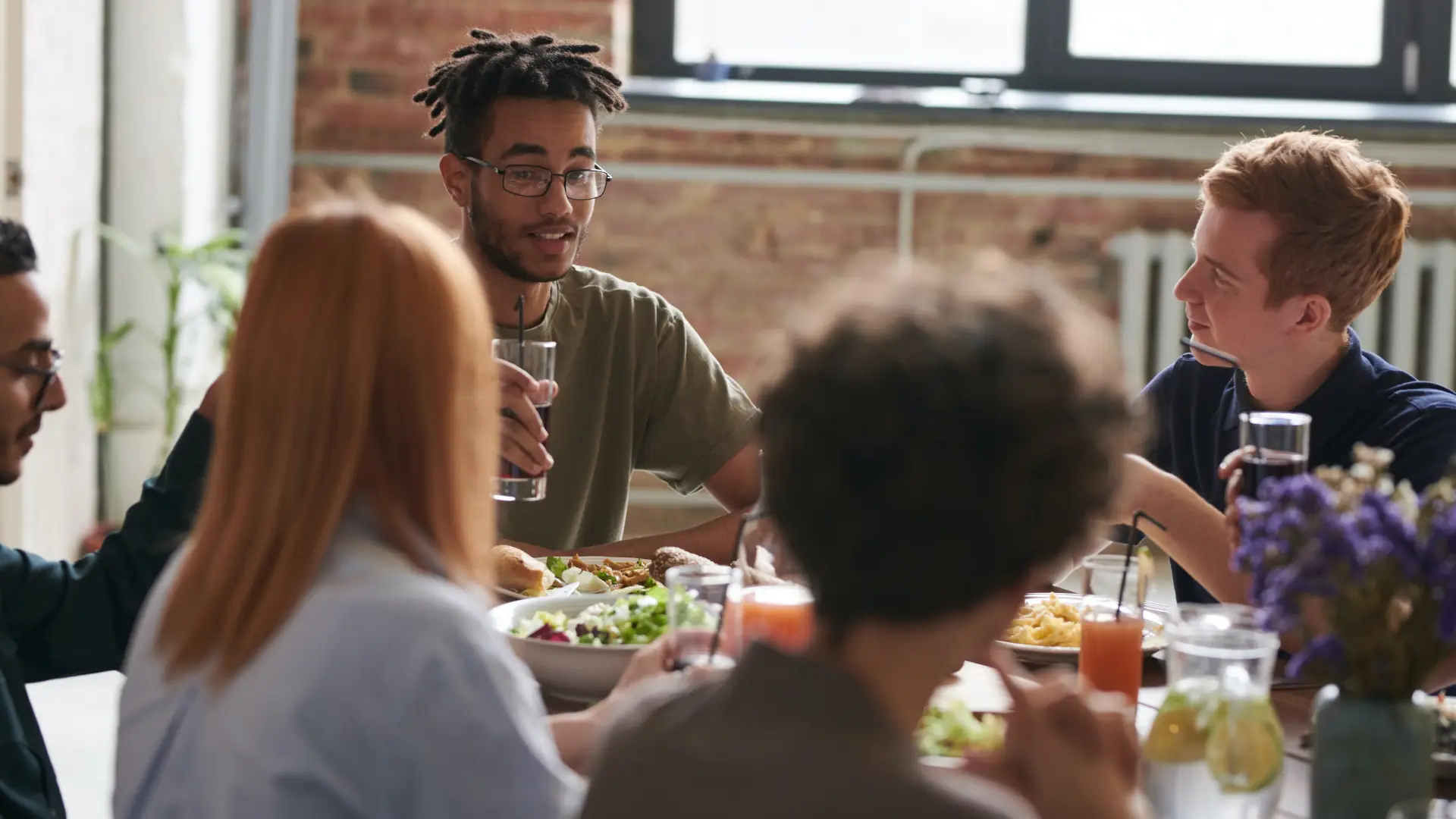 Gruppe junger Menschen beim Essen an einem Tisch