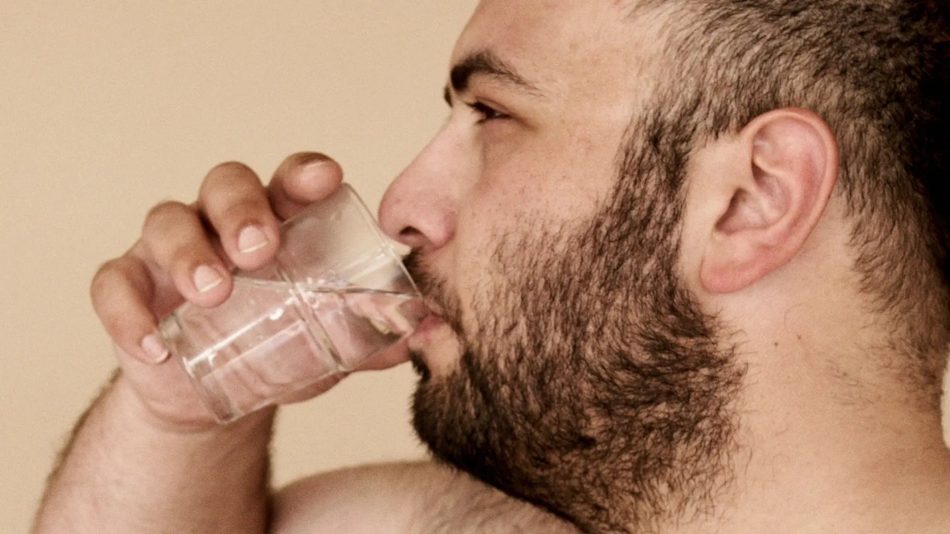 Übergewichtiger Mann trinkt ein Glas Wasser